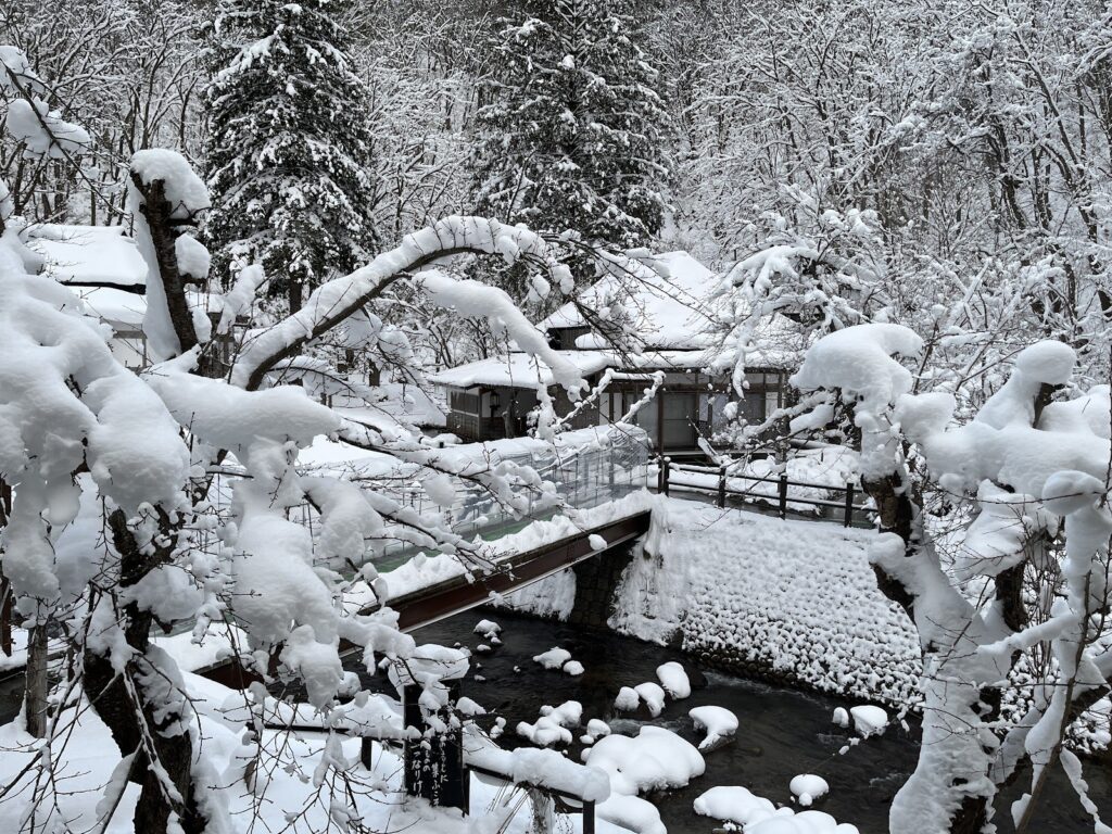 雪の渓流沿いにある露天風呂