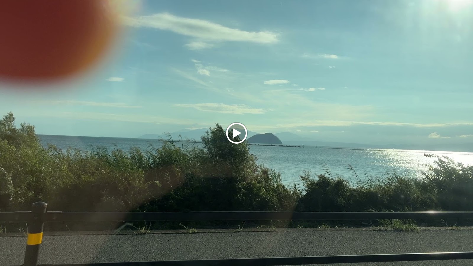 湖北の湖岸道路から。沖に浮かんでいるのが竹生島です
