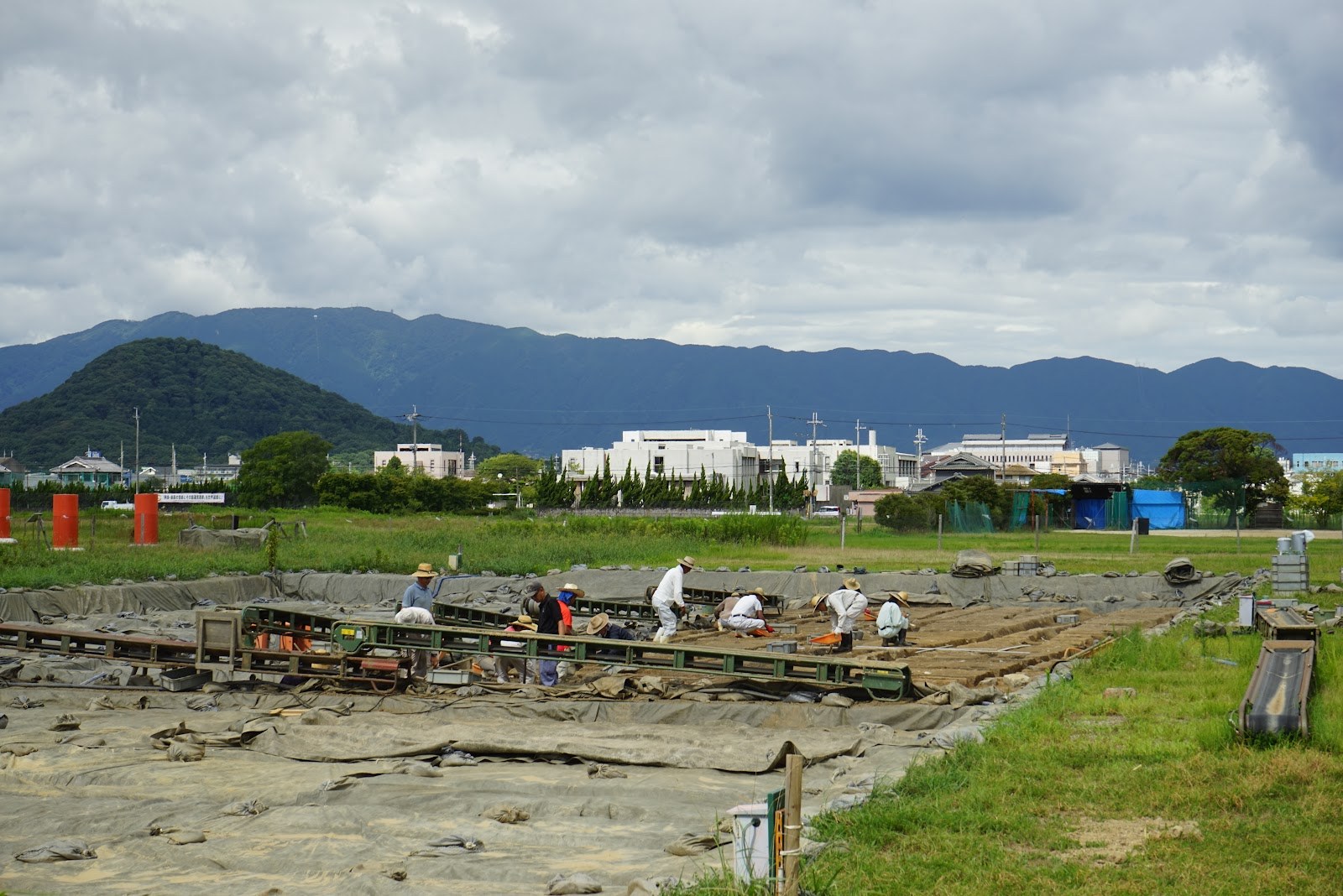 発掘調査で作業する人たち。掘り出された遺構が見える