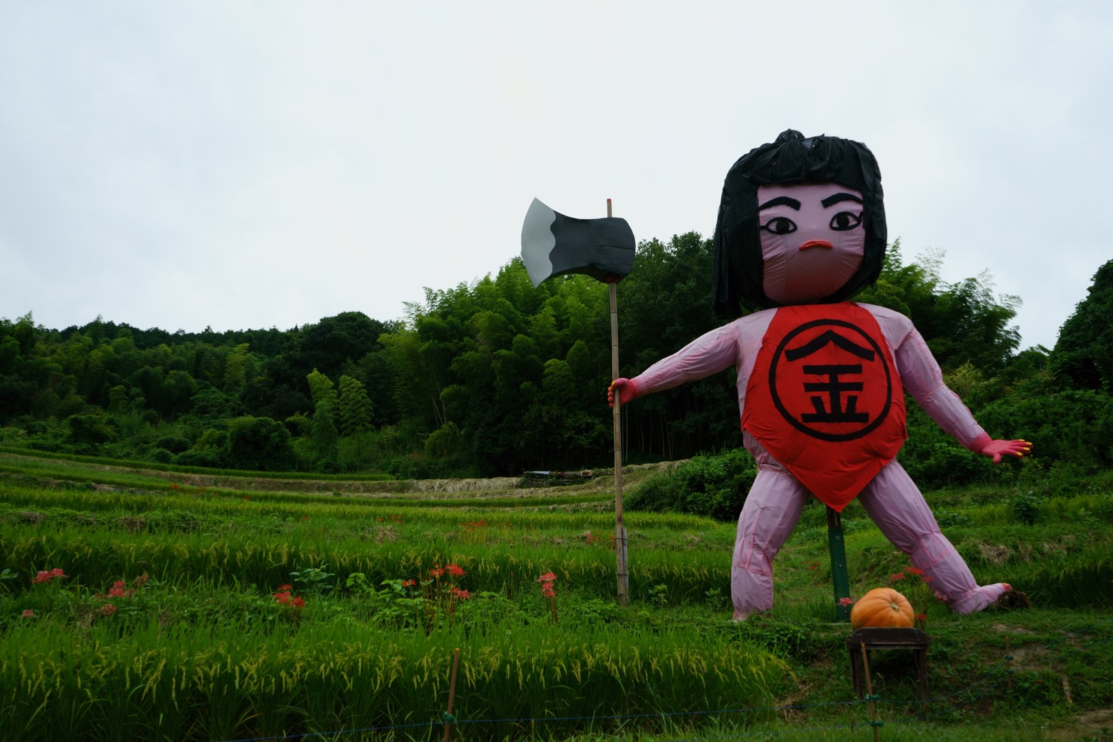 金太郎の姿をした案山子。まさかりを持って田んぼに立つ