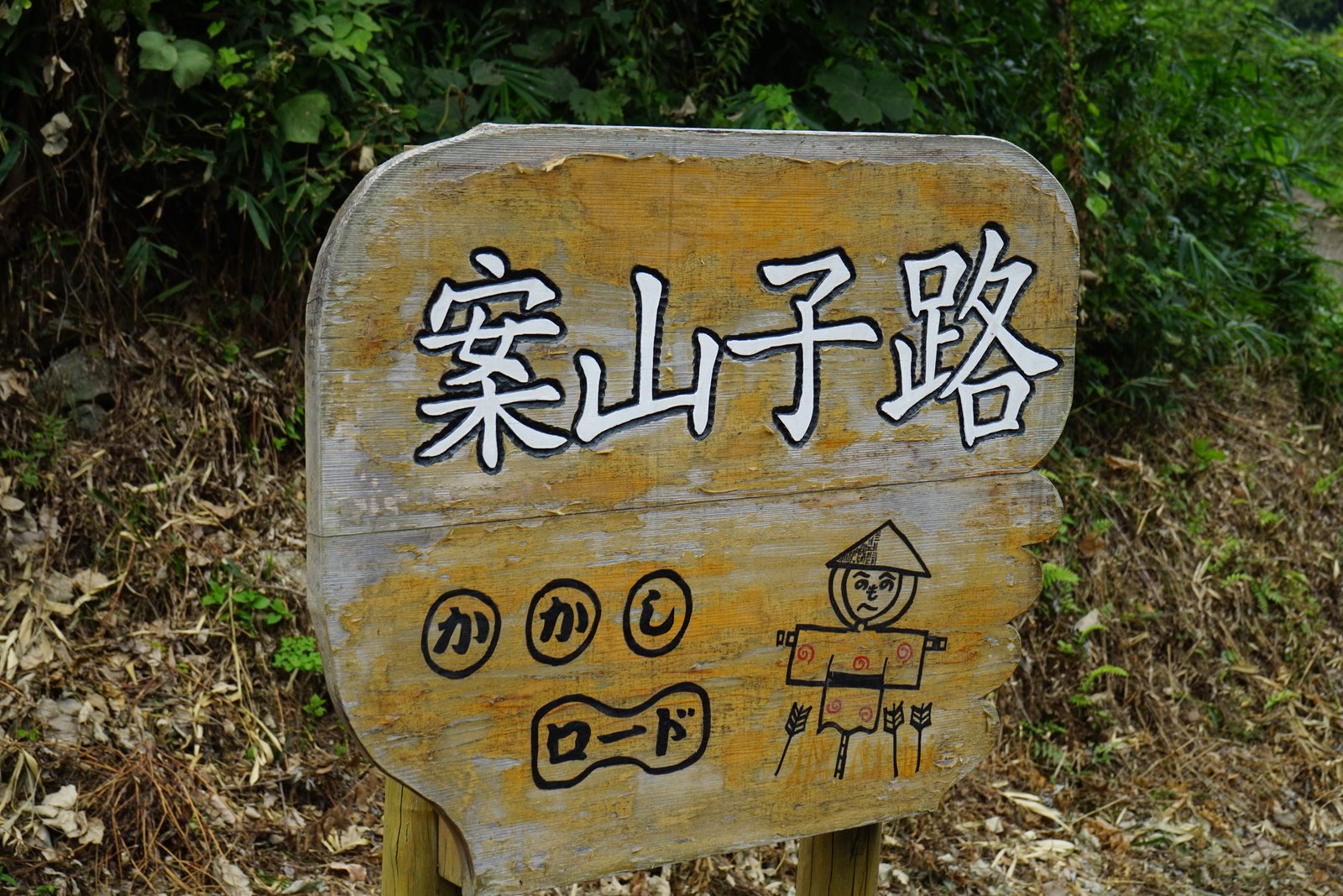 「案山子路(かかしロード)」と書かれた木の看板
