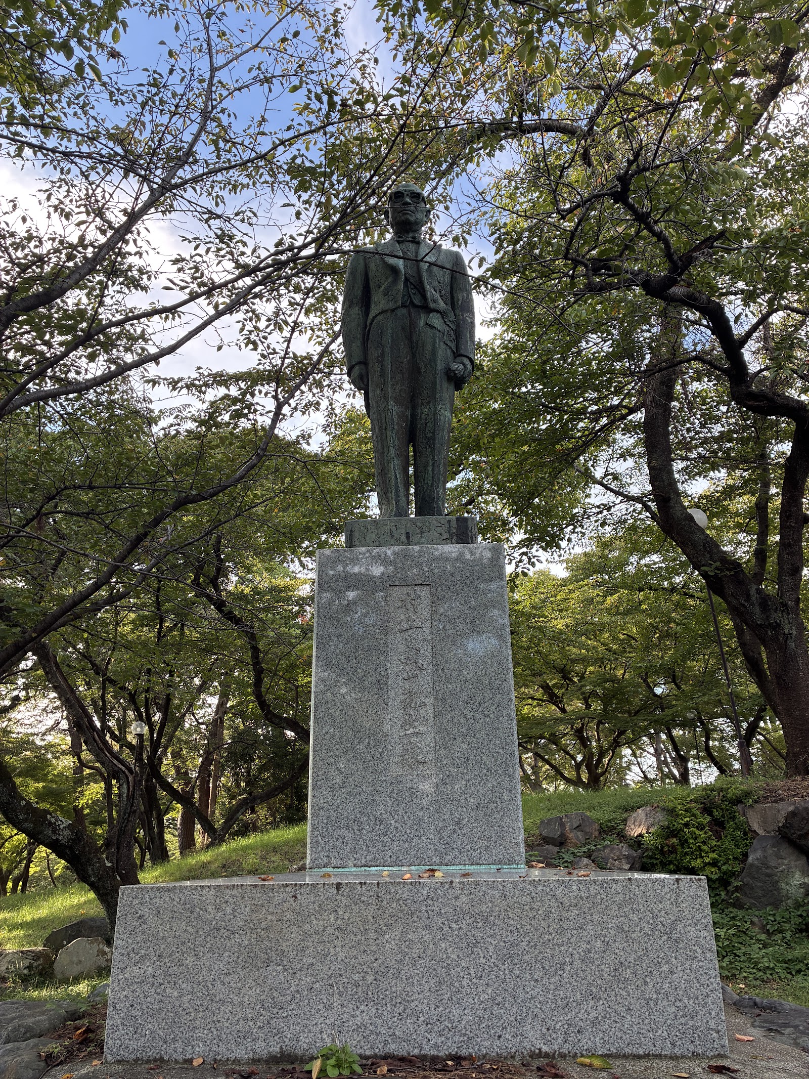 豊公園に立つ村上義一の銅像。背広に眼鏡の近代の人物像です