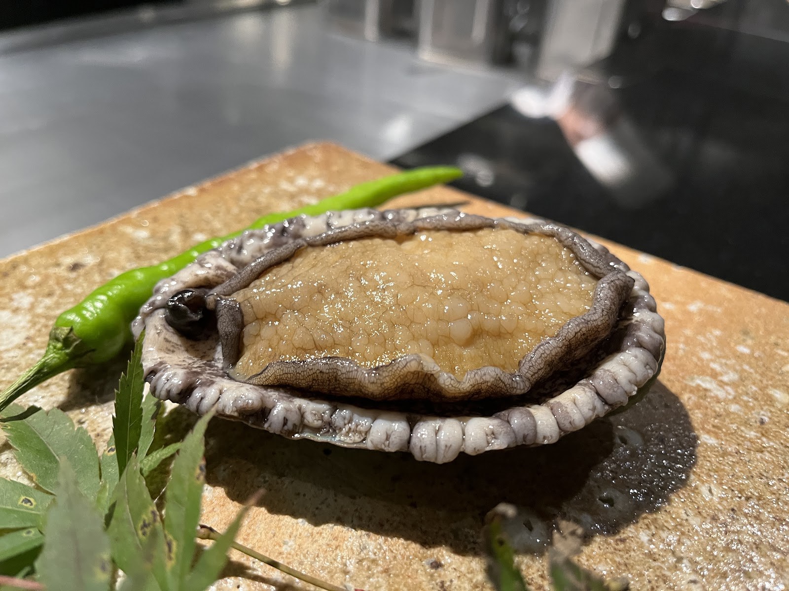焼く前の蝦夷鮑。肝がついたまま鉄板の横に置かれている