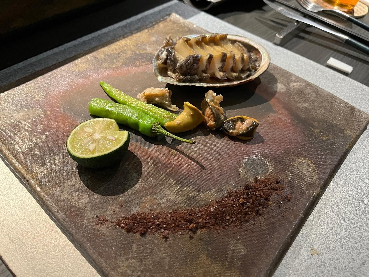 鮑の鉄板焼き。肝ソースとすだち、万願寺とうがらし