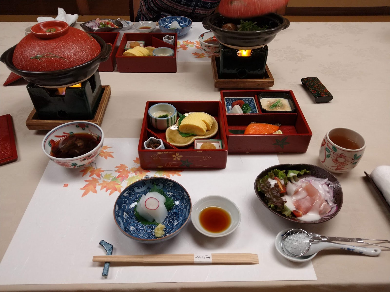 月日亭の朝食の膳の全景。鍋と重箱が並ぶ